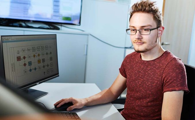 Ein Student des Fachbereichs Software Engineering Embedded Systems sitzt bei RAFI an seinem Arbeitsplatz in der Softwareentwicklung