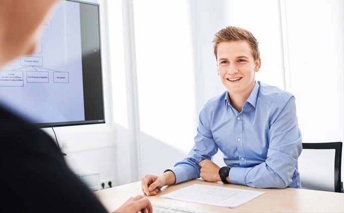 Ein Student des Fachbereichs Elektrotechnik bespricht sich mit seinem Ausbilder bei RAFI., Student im Besprechungsraum